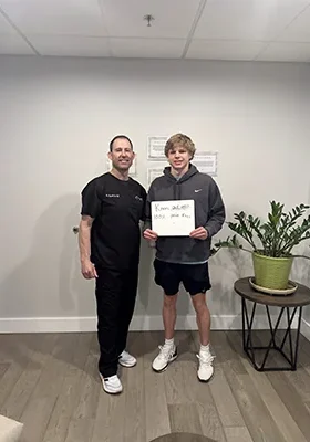 Dr. Derek Fox posing with a happy SoftWave patient who is an athlete